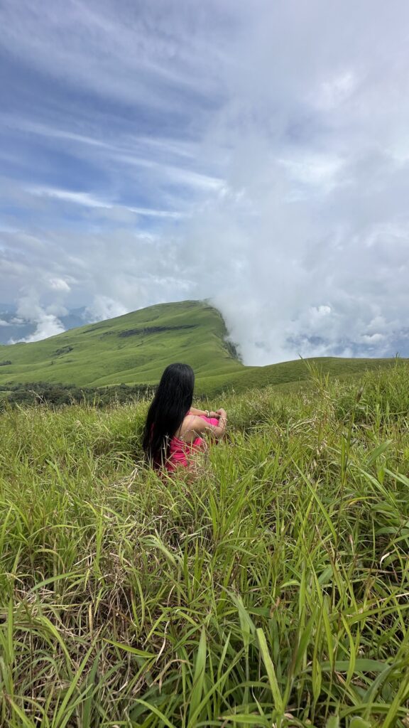Trekker walking through misty grasslands on the Netravati Trek trail